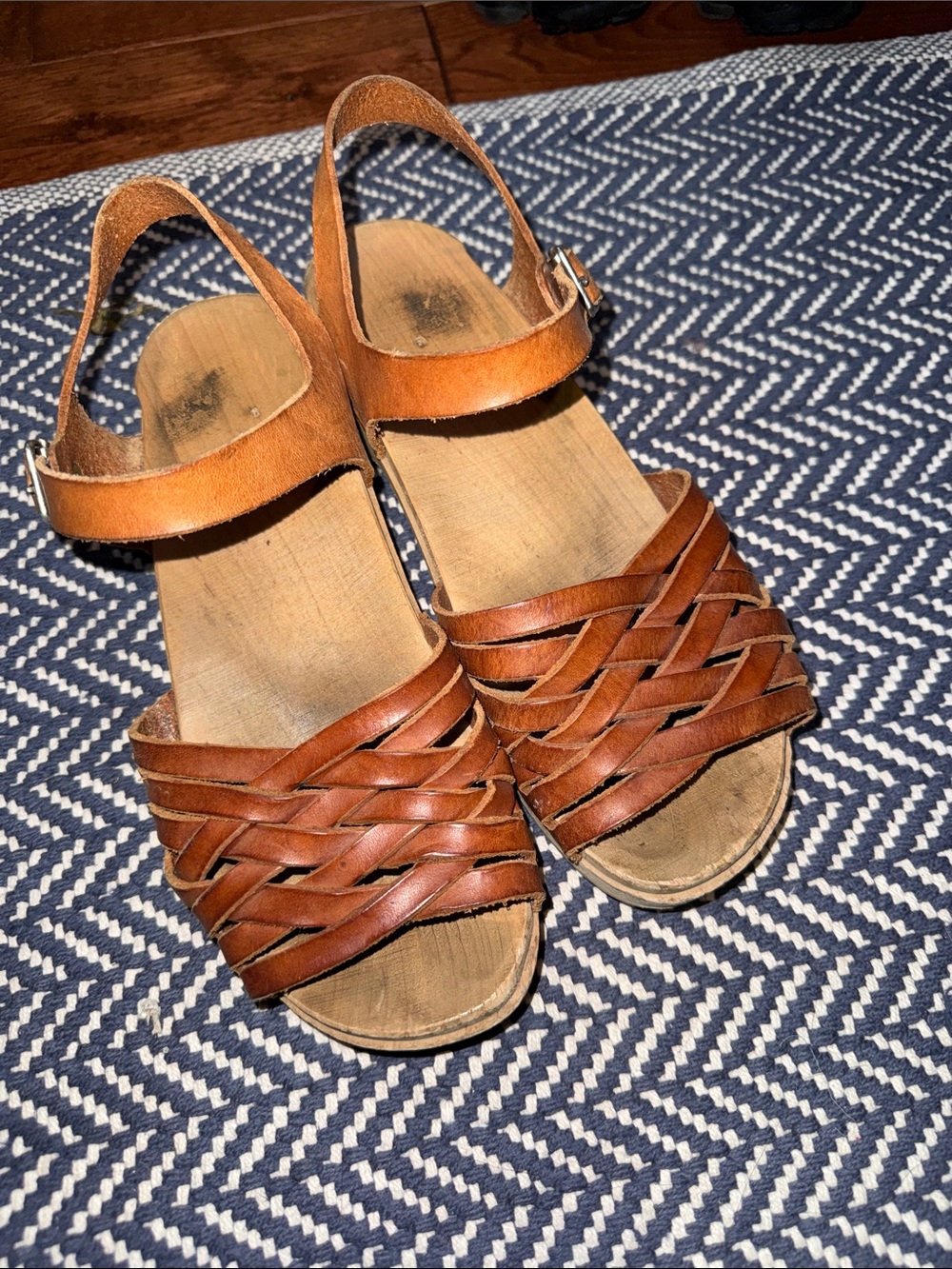 Women’s brown, leather, wooden clogged sandals.
